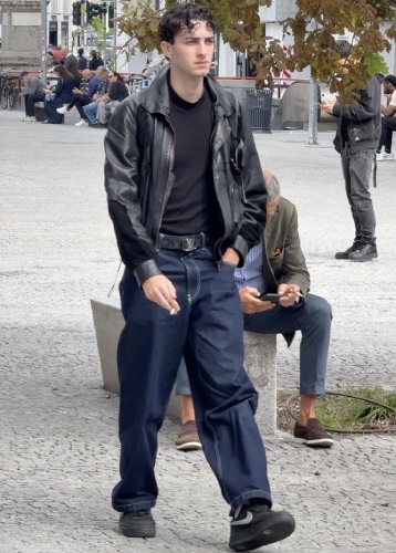 black leather bomber jacket paired with dark-wash baggy jeans