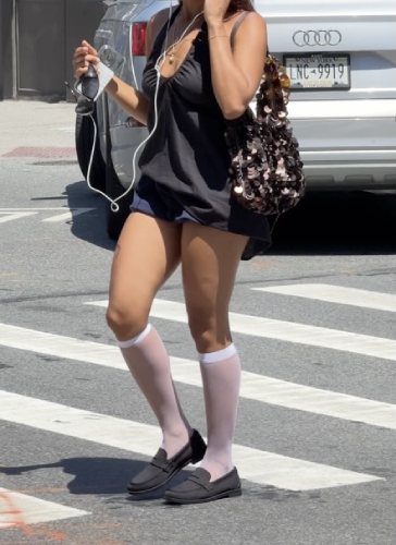 black Penny Loafers with white sheer knee-high socks, a black halter top, and a sequined bag