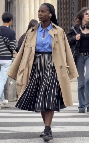 blue-and-white striped button-down tucked into a pleated black and white striped skirt